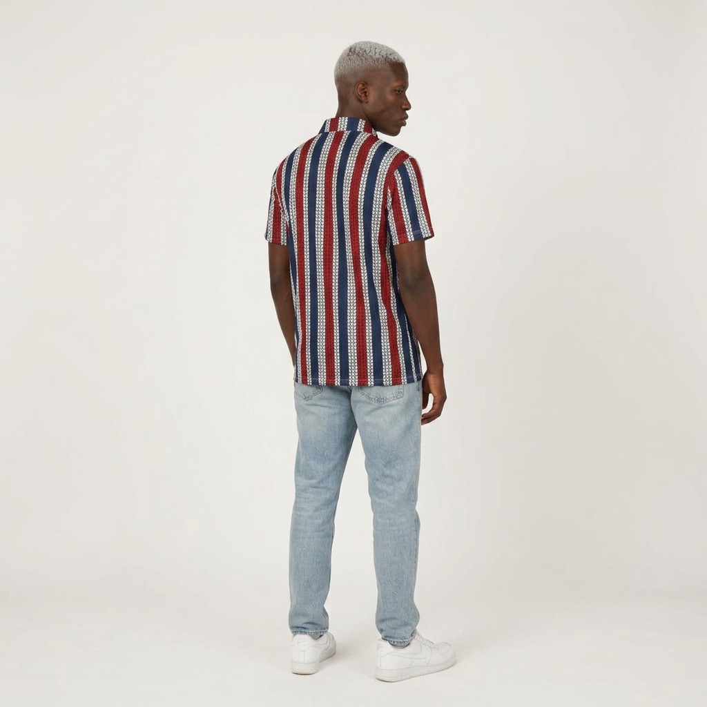 A man wearing a short-sleeve button-up shirt with vertical red, blue, and white stripes, paired with light-wash jeans and white sneakers, shown from the back against a plain white studio background.