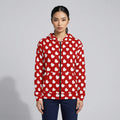 Person wearing a red hoodie with white heart patterns on a gray background